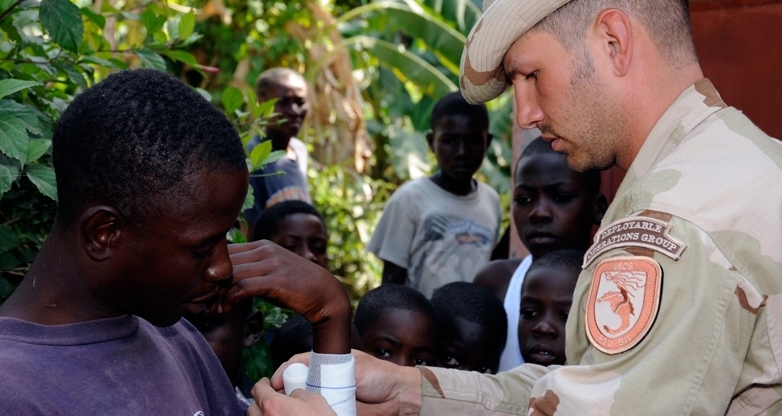 PORT-AU-PRINCE, Haiti - U.S. Coast Guard Petty Officer 2nd Class Jeremiah Romankowski, a health services technician from Salt Lake City, Utah attached to the Port Security Unit 311, administers basic first aid to citizens in the town of Leogane, Feb. 14, 2010.