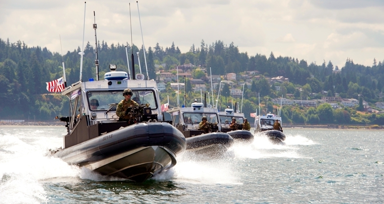 Boat crews from Coast Guard Port Security Unit 313in Everett, Wash., conduct high-speed boat maneuvers and safety zone drills during an exercise at Naval Station Everett July 22, 2015. The exercise was held in an effort to fine tune their capabilities in constructing and running entry control points, establishing perimeter security, and maintaining waterside security and safety zones.